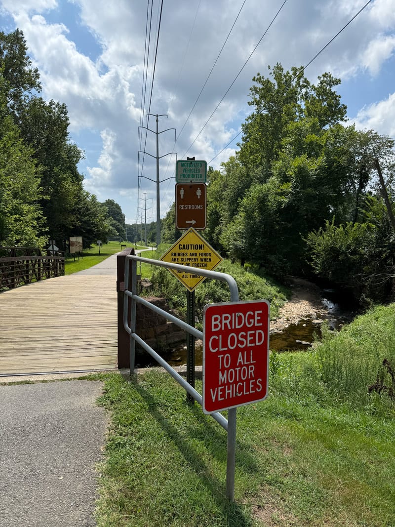 New and old park signs at Bluemont Park; the newer sign uses high-contrast text