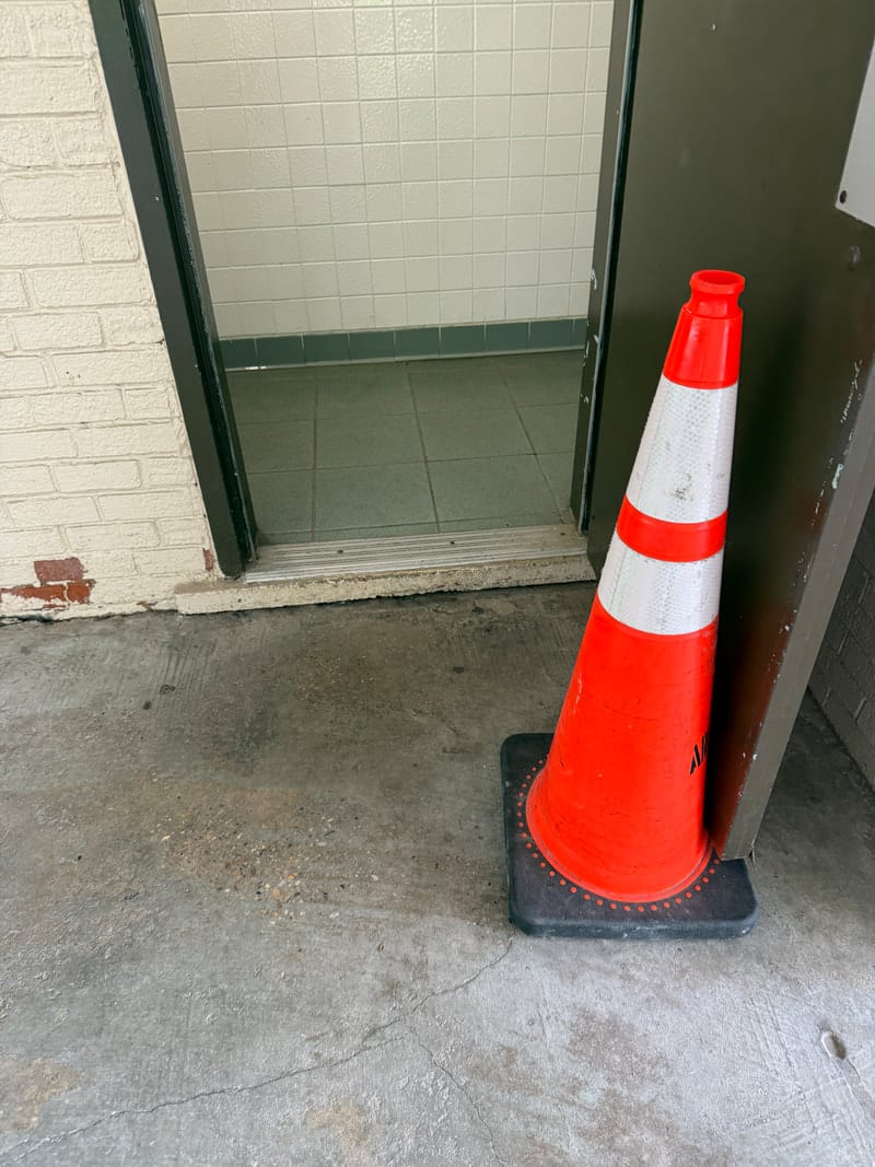 A restroom entrance at Bluemont Park marked with the accessibility symbol but blocked by a step