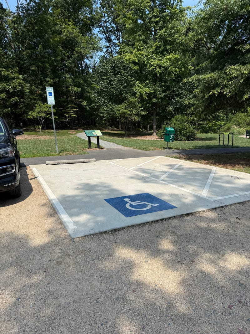 One paved accessible parking space in a gravel lot at Potomac Crossing Park